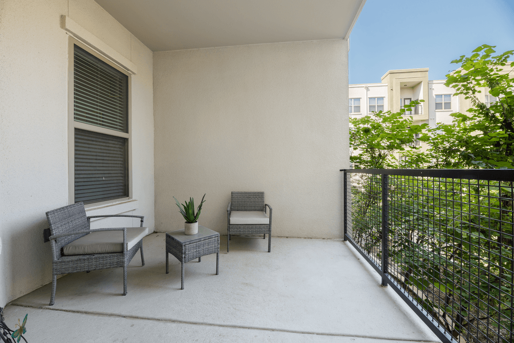 A patio with a couch, chair, and table.