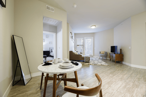A living room with a dining table and chairs.