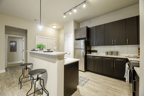 A kitchen with a white counter and black cabinets.