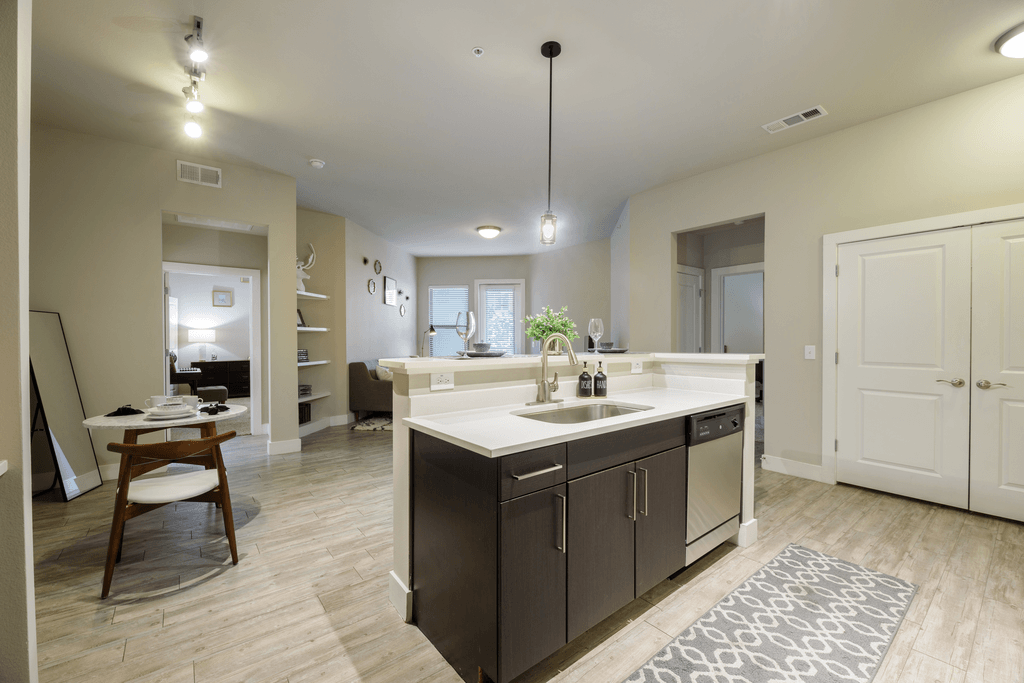 A kitchen with a sink a counter and a dining table