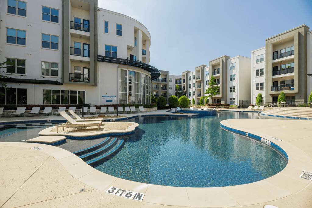 A swimming pool in front of apartment buildings.
