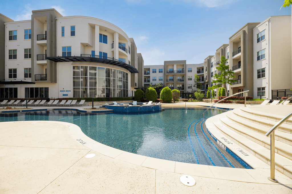A swimming pool in front of apartment buildings.