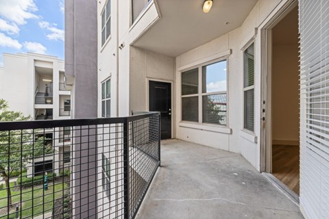 A balcony with a black railing and a view of a building.