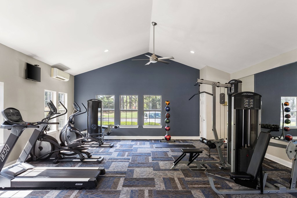 the gym with treadmills and other exercise equipment in a home with blue walls