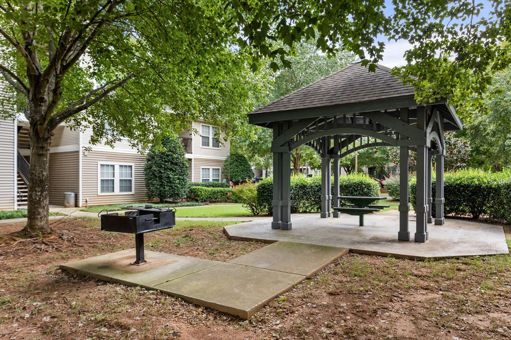 a gazebo with a picnic table and a grill