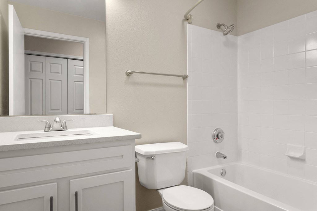 a white bathroom with a toilet and a tub and a sink