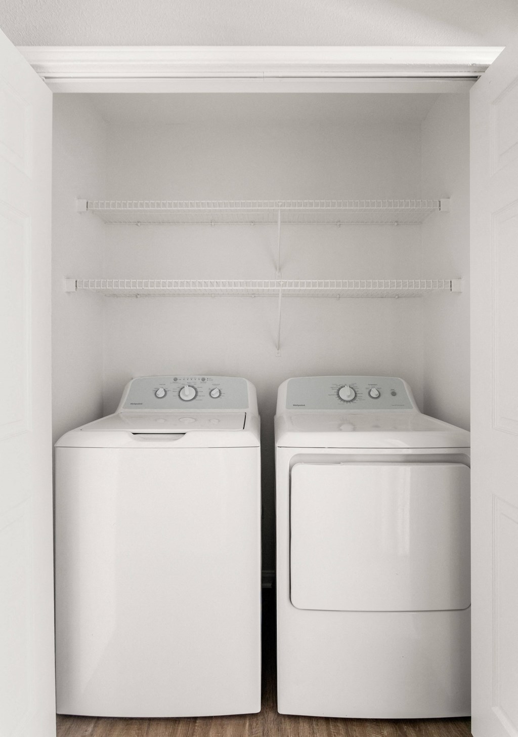 an empty laundry room with two washes and a dryer