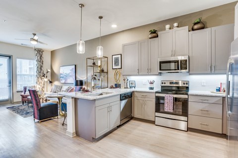 a kitchen with white cabinets and stainless steel appliances and a table with chairs