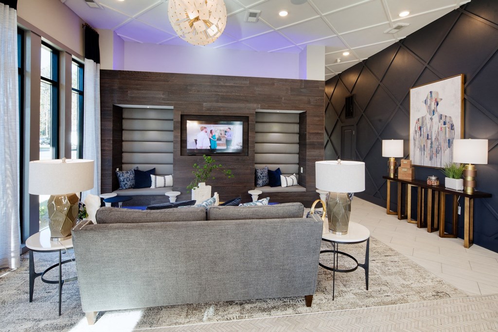 a living room with couches and lamps and a television