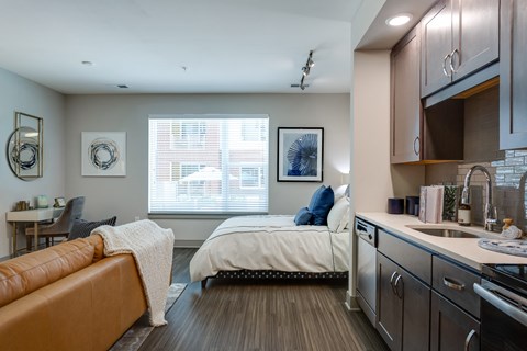 a bedroom with a bed and a kitchen with a sink