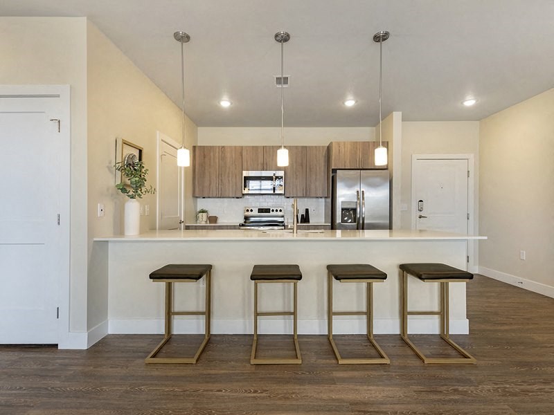 a kitchen with a bar and three stools