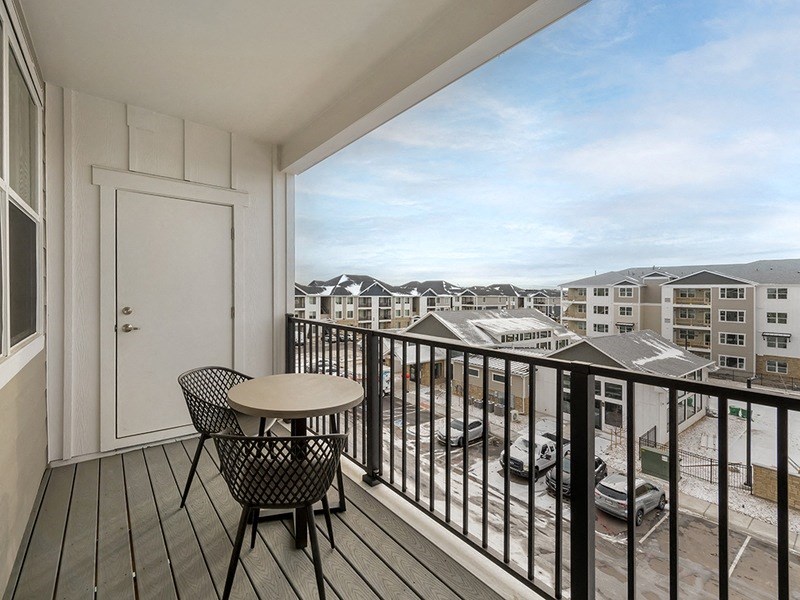 a balcony with a table and two chairs and a view of the ocean