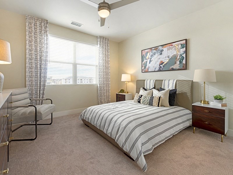 a bedroom with a bed and a chair and a window