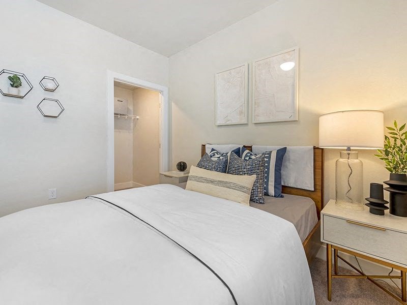 a small bedroom with a bed and a night stand