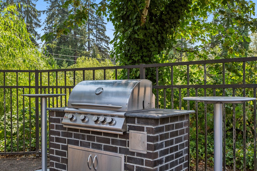 a barbecue grill in a backyard with a table