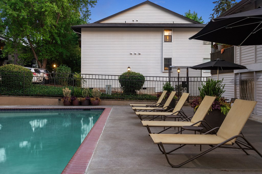 a group of lounge chairs sitting next to a swimming pool