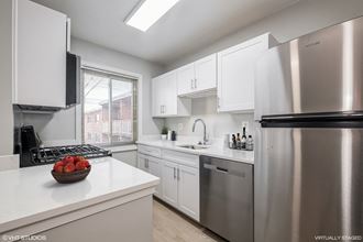 Model kitchen with white countertops, stainless steel appliances