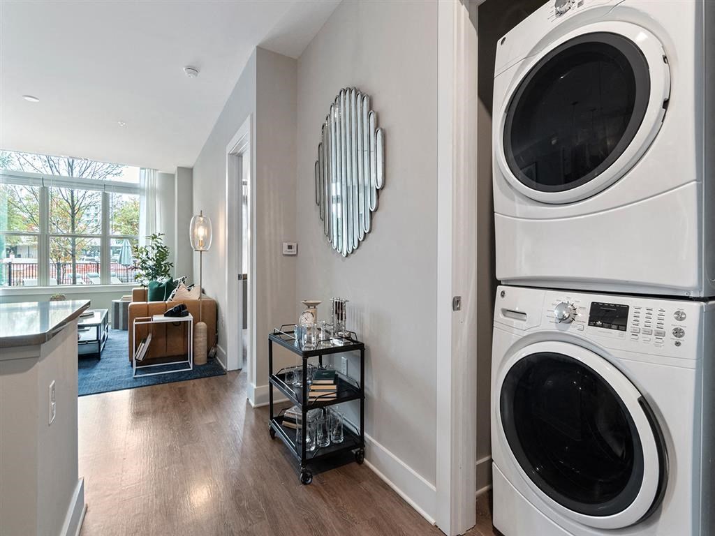 A modern laundry room with a washer and dryer stacked on top of each other.