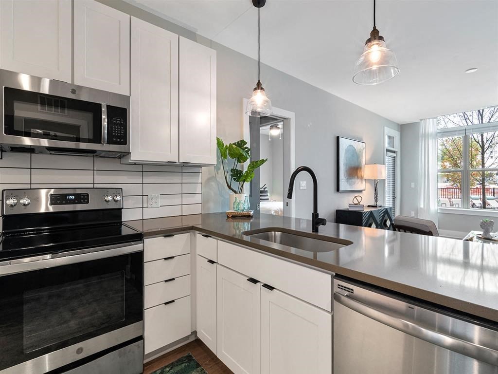 A modern kitchen with stainless steel appliances and white cabinets.