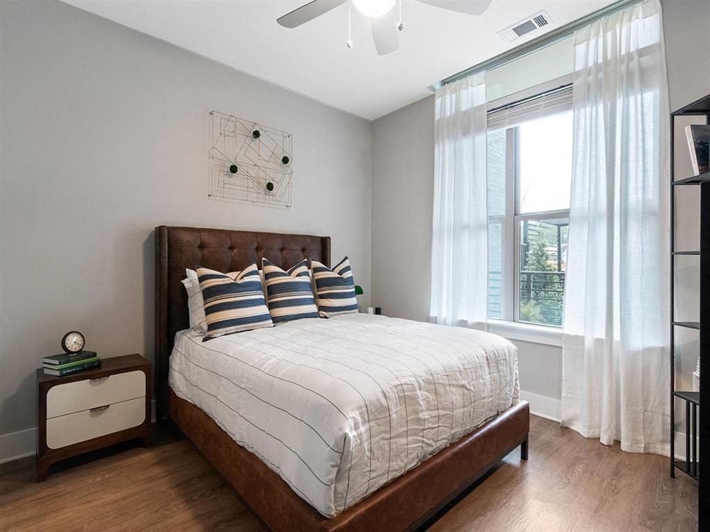 A bedroom with a large bed and a ceiling fan.