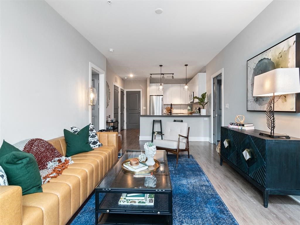 A living room with a tan couch and a black coffee table.