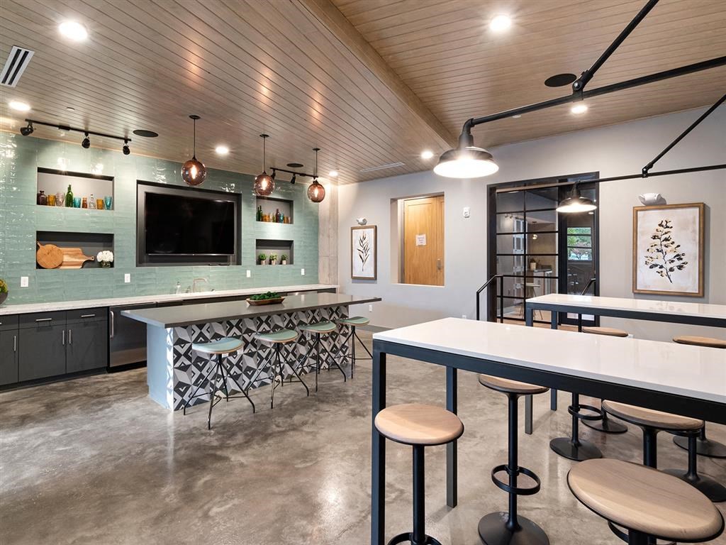 A modern kitchen with a bar area and a television.