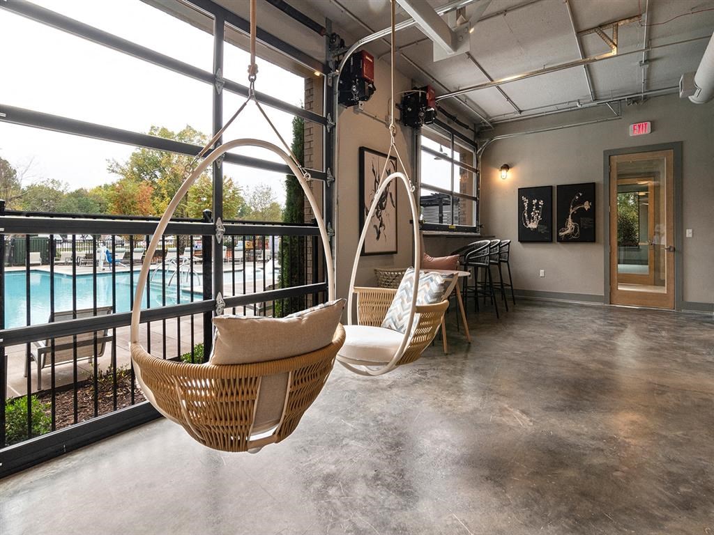 A room with a hanging chair and a table.