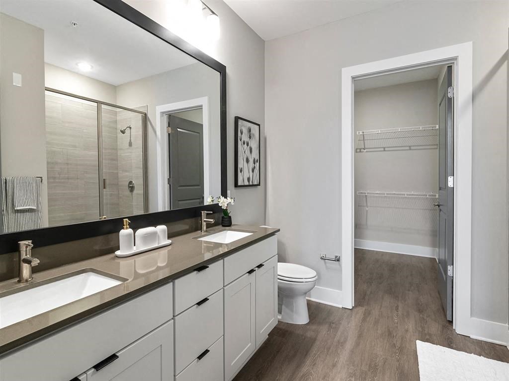 A bathroom with a toilet, sink, and mirror.