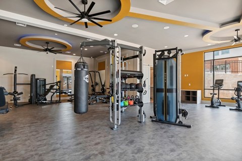 A gym with a variety of equipment including a punching bag, treadmills, and weights.