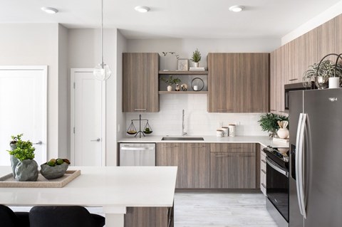 A modern kitchen with a white table and a black refrigerator.