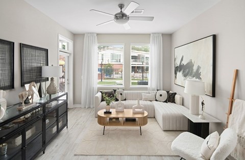 A modern living room with a white sofa, a wooden coffee table, and a large painting on the wall.