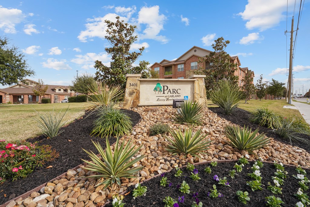 our front sign is in front of our building with landscaping and flowers