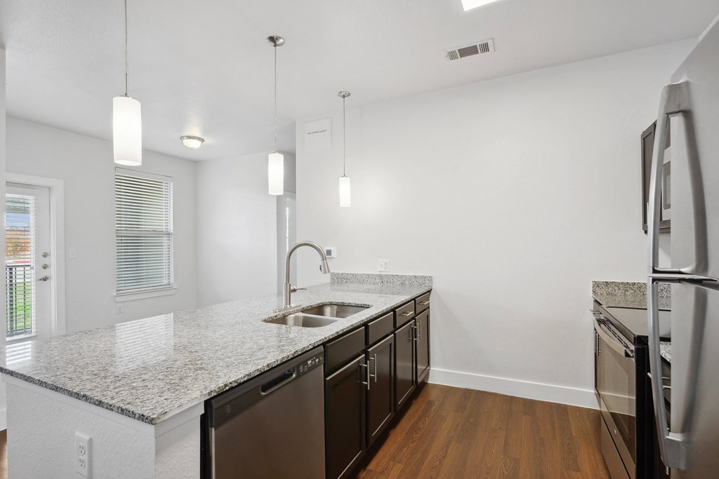 a renovated kitchen with granite counter tops and stainless steel appliances