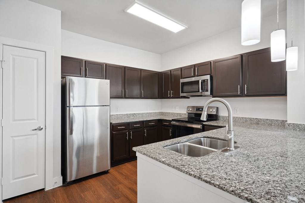 a kitchen with granite counter tops and stainless steel appliances