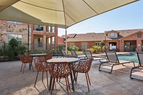 A patio with a table and chairs under a canopy.
