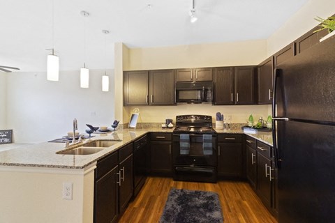 a large kitchen with black appliances and granite counter tops