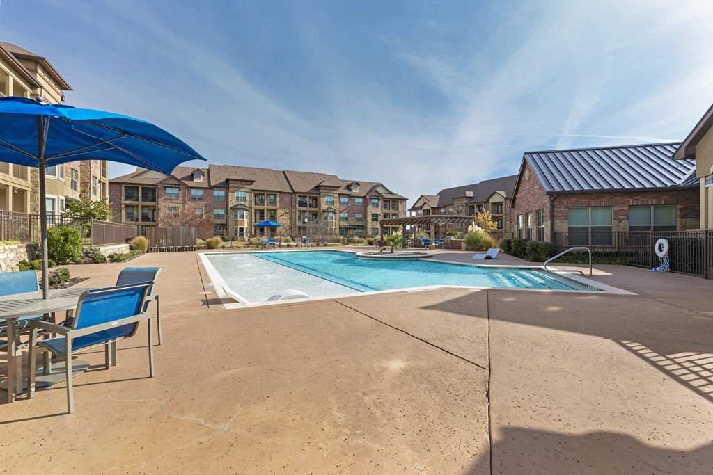 our apartments have a resort style pool with chairs and umbrellas