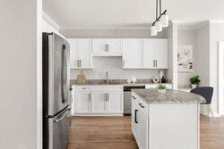 a kitchen with white cabinets and a stainless steel refrigerator