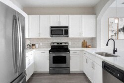 a white kitchen with a stove and a refrigerator
