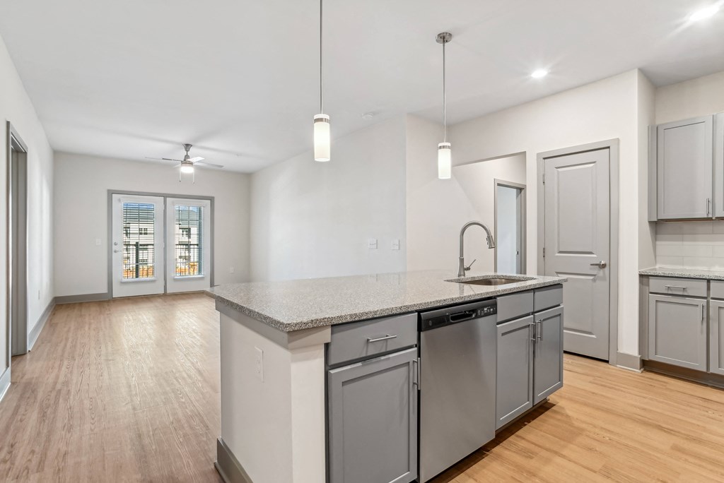 an open kitchen and living room with a large island with a sink
