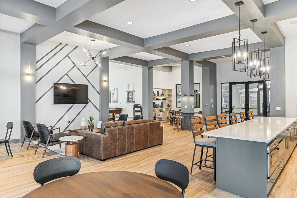 a living room with couches tables and chairs and a kitchen