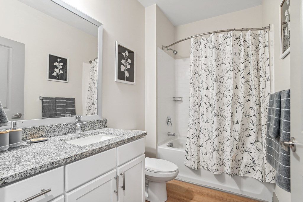 a bathroom with a shower curtain and a sink and a toilet