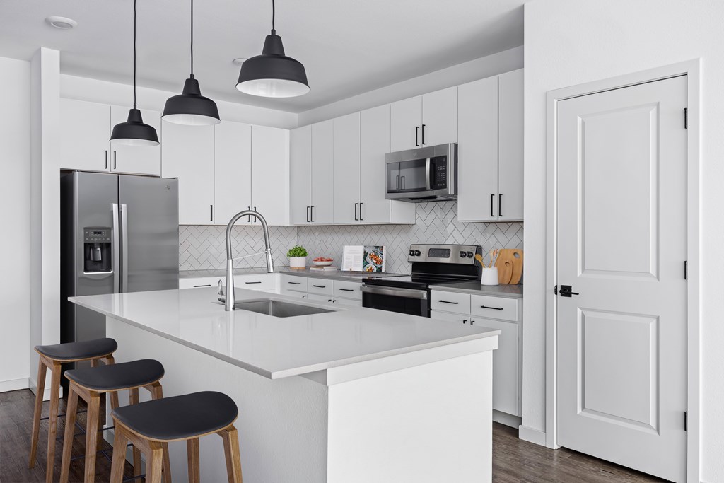 A kitchen with white cabinets and a white countertop.