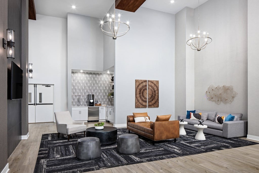 A modern living room with a grey sofa, a black coffee table, and a wooden floor.