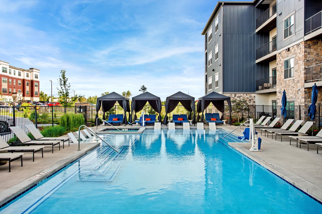 A large swimming pool with sun loungers and umbrellas.