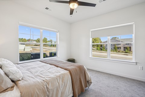 a bedroom with a bed and two windows