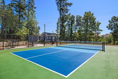 A tennis court with a blue surface and white lines.