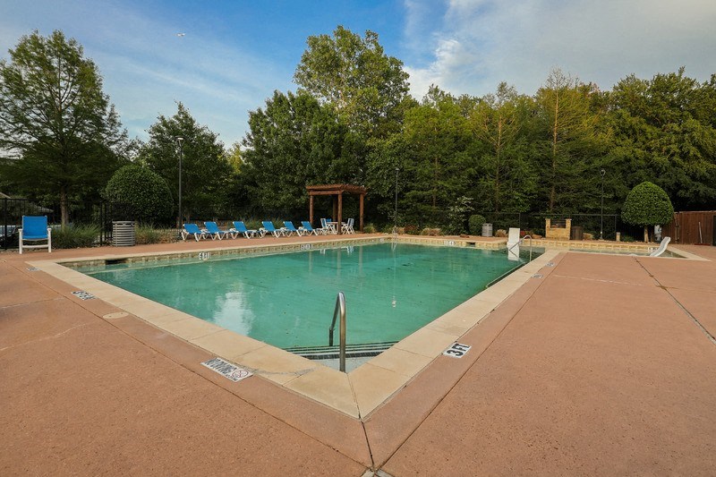 a swimming pool with blue chairs around it