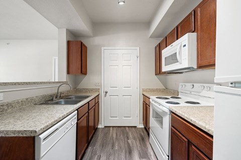 A kitchen with white appliances and wooden cabinets.