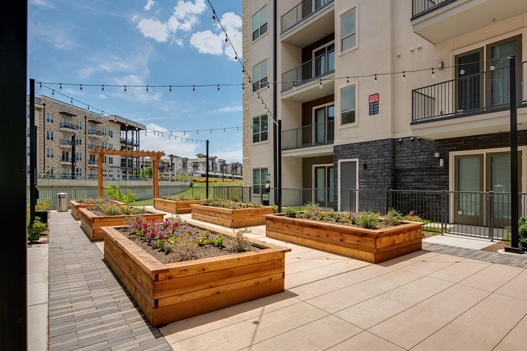 an outdoor patio with wooden planters and plants in an apartment building